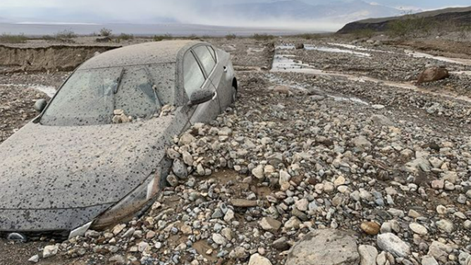A car is seen surrounded by rocks and debris after flash flooding in Death Valley.