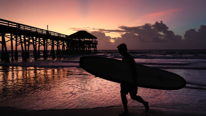 Surfer Scott Norwood prepares to go in the water as Hurricane Dorian approaches Florida, on August 31, 2019 in Cocoa Beach, Florida.