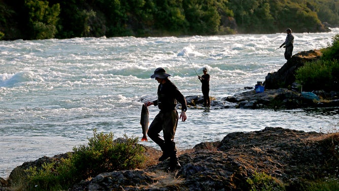Anglers fish for sockeye salmon along the rapids of the Newwhalen River near Iliamna, Alaska.