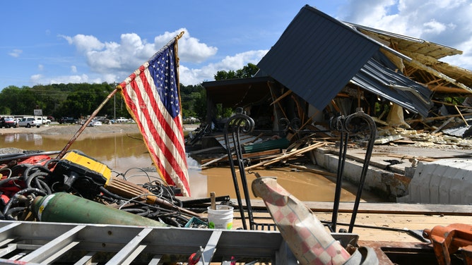 An American flag flies amidst the devastation caused by floodwaters in Waverly, TN.