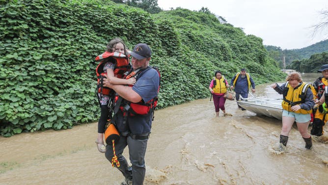 Stranded residents of Jackson, Kentucky, are evacuated by boat.