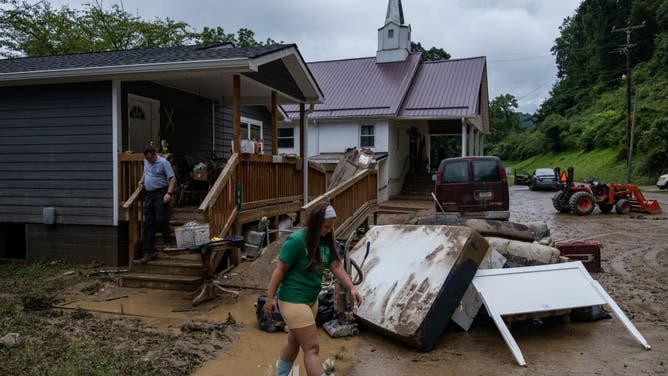 A local fire chief and his daughter drop off goods for a local community member in Jackson, Kentucky, on July 31, 2022. - Rescuers in Kentucky are taking the search effort door-to-door in worsening weather conditions as they brace for a long and grueling effort to locate victims of flooding that devastated the state's east, its governor said on July 31, 2022. (