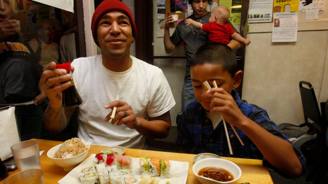 A father and son enjoy sushi, such as salmon roll, in northern California.
