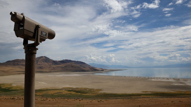 A telescope peer out over the Great Salt Lake, with once underwater lakebed exposed.