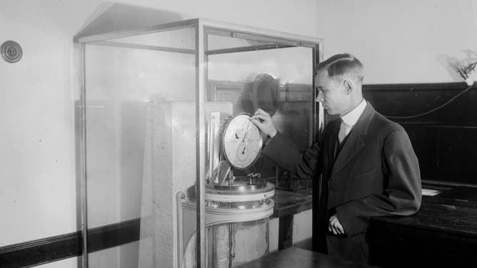 Charles C. Wylie setting back the clock at the Naval Observatory ca. between 1918 and 1928.