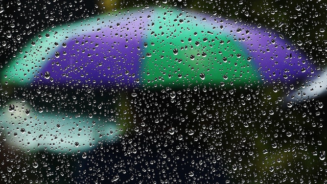 FILE - A photo showing rain and an umbrella.