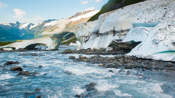 Waters rush past a glacier in Alaska.