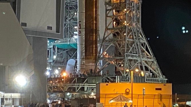 People near NASA's SLS rocket and Orion spacecraft as it leaves the Kennedy Space Center Vehicle Assembly Building on Aug. 16, 2022. The Artemis-1 rocket was moved to launchpad 39B ahead of the late August launch to the moon.