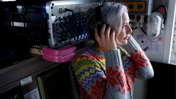 Scientist Kirsten Thompson listens to whales sounds from the Hydrophone.