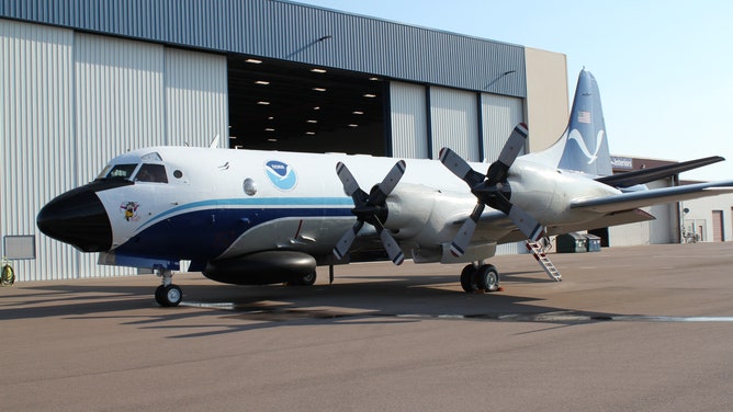 NOAA Lockheed WP-3D Orion aircraft with a Miss Piggy logo near the nose of the aircraft.