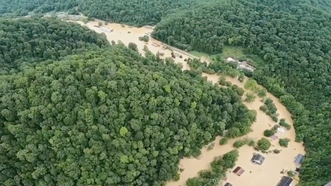 An aerial view of Jenkins, Kentucky. The rooftops of nearly submerged homes can barely be seen in the brown floodwaters.