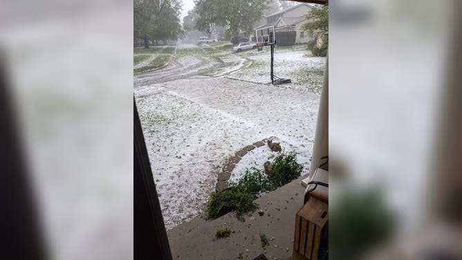 Hail stones cover a yard in Des Moines, Iowa on Aug. 19, 2022.