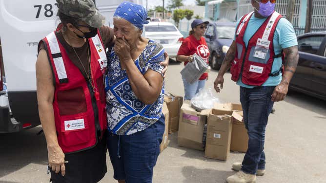 Red Cross volunteer Betzaida comforts her former schoolteacher, Carmen who she encounters while distributing relief supplies to comunidad Playita. Carmen is one of the many residents that got affected by flooding that received emergency supplies in the community of Playita from the American Red Cross.