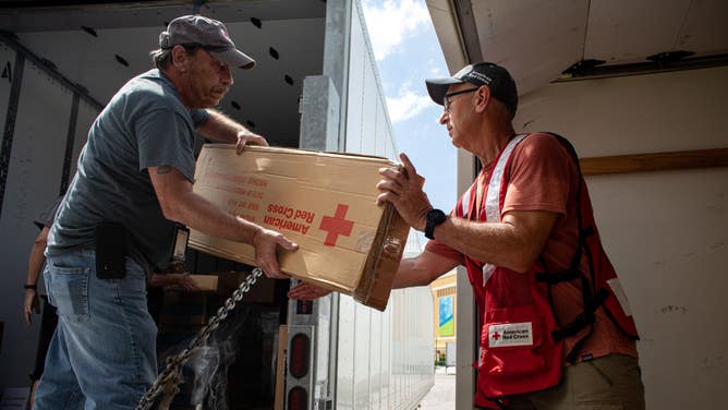 Red Cross Fulfillment Team volunteers working ahead of Hurricane Ian, unload tractor trailers of supplies at the ESPN Center in Orlando, Fl. 