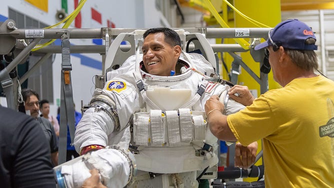 NASA file photo: Astronaut Frank Rubio being helped into a spacesuit prior to underwater spacewalk training at NASA Johnson Space Center’s Neutral Buoyancy Laboratory in Houston.