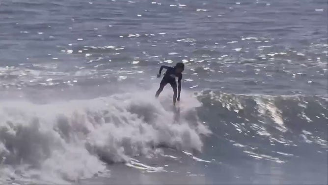 A surfer rides a wave off Nags Head, North Carolina, on Thursday, Sept. 22, 2022.