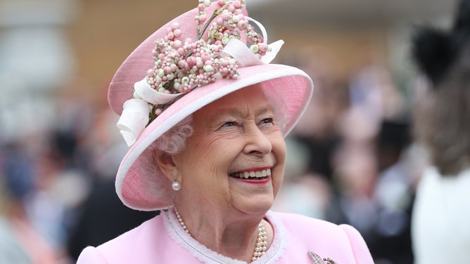 LONDON, ENGLAND - MAY 29: Queen Elizabeth II meets guests as she attends the Royal Garden Party at Buckingham Palace on May 29, 2019 in London, England.