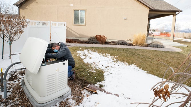 A worker from Captain Electric makes final inspections on a newly installed 24-kilowatt Generac home generator on February 18, 2021 in Orem, Utah.
