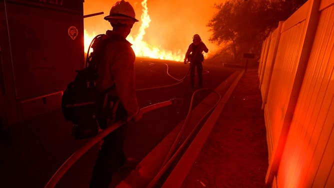 Firefighters wait to provide structure protection as the Fairview fire approaches homes near the corner of Citrus View Drive and Fairview Avenue near Hemet on Wednesday night Sept. 7, 2022