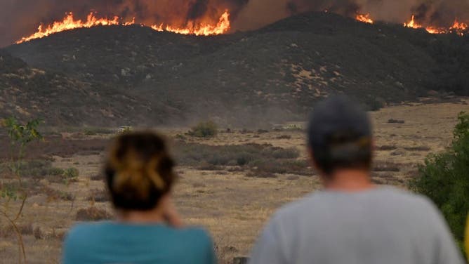 Residents watch as the Fairview fire slowly approaches homes at the top of Fairview Avenue in Hemet on Wednesday, Sept. 7, 2022.