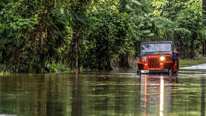 Juan Antonio Molina drives his old jeep through a road flooded in Toa Alta by Hurricane Fiona that passed by Puerto Rico on Monday Sept. 18, on Wednesday, Sept. 20, 2022. 
