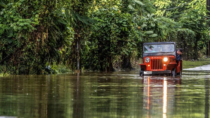 Juan Antonio Molina drives his old jeep through a road flooded in Toa Alta by Hurricane Fiona that passed by Puerto Rico on Monday Sept. 18, on Wednesday, Sept. 20, 2022.