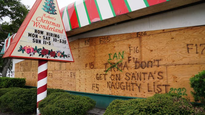 A Christmas themed store is boarded up with messages for Hurricane Ian on September 27, 2022 in Clearwater, Florida.