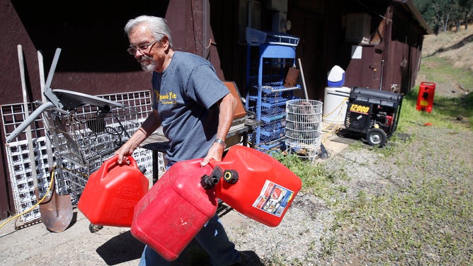 Jerry Rehmke gathers empty gas cans to take to refill for the gas generator behind the Spanish Flat Country Store and Deli in Lake Berryessa, Calif. on Saturday, June 8, 2019.