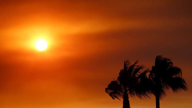 The sun sets through the haze of wildfire smoke as the Fairview Fire burns on September 6, 2022 near Hemet, California.