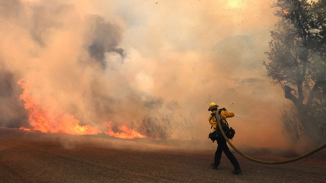 A firefighter works at a back burn during the Fairview Fire on September 7, 2022 near Hemet, California.