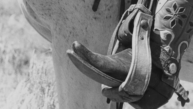 A cowboy boot in a stirrup.