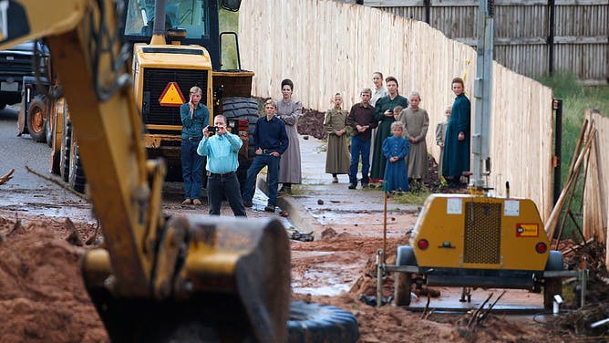 People take pictures and watch as construction equipment removes flood debris from Short Creek as it crosses Central Street on September 15, 2015 in Colorado City, Arizona.