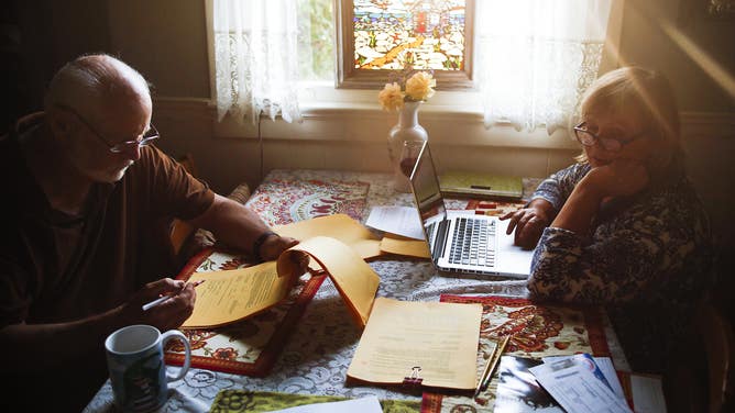 A couple sits at a dining table paying the family bills in Redondo Beach, California.