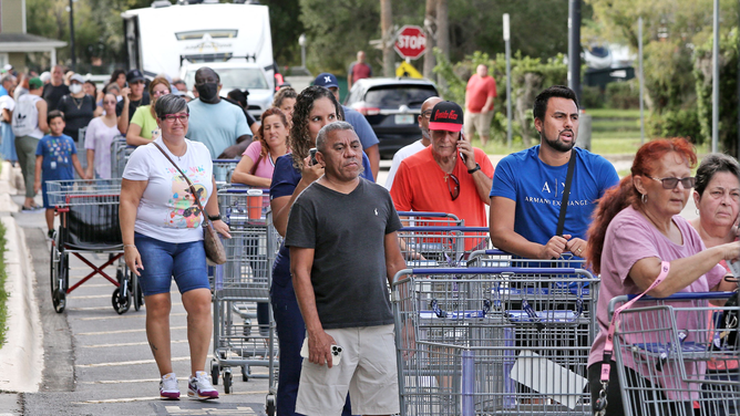 Shoppers wait in line outside a retail warehouse as people rush to prepare for Tropical Storm Ian, in Kissimmee, Florida, on September 25, 2022.