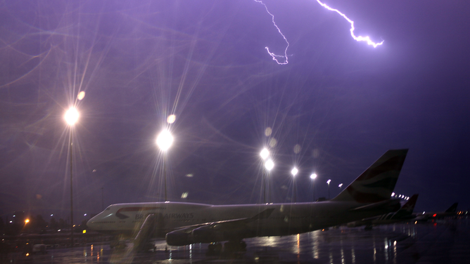 FILE - Lightning strikes over a British Airways international flight at Johannesburg International airport on October 23, 2009 in Johannesburg, South Africa.