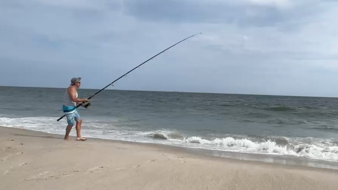 The tension in the reel indicates that something large lies beneath the surface.