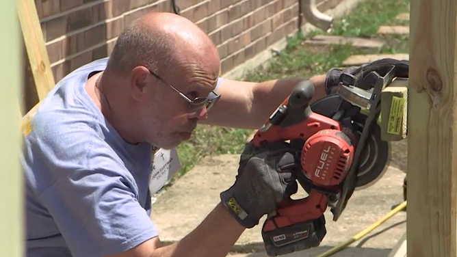 An Eight Days of Hope volunteer helps to rebuild a home.