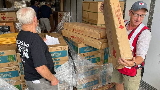 Red Cross volunteers working ahead of Hurricane Ian unload tractor trailers of supplies that will be heading to evacuation shelters in Florida. The supplies include cots, blankets, gloves, flashlights and clean-up kits.