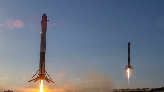 Two Falcon Heavy rocket boostes returning to land at Cape Canaveral Landing Zone 1 after launching the Arabsat-6A satellite from Kennedy Space Center in Florida on April 11, 2019.