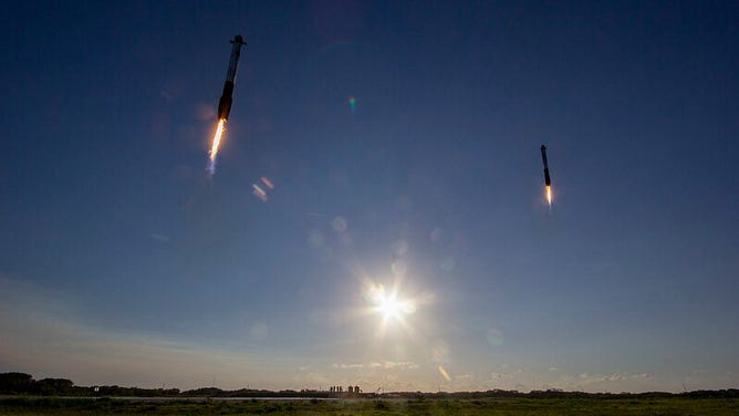 Two Falcon Heavy rocket boostes returning to land at Cape Canaveral Landing Zone 1 after launching the Arabsat-6A satellite from Kennedy Space Center in Florida on April 11, 2019.