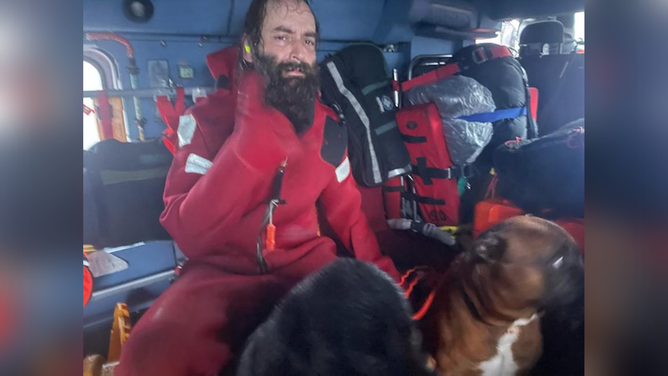 Shown is Robert Johnson and his two dogs who were rescued by a Coast Guard Air Station Sitka aircrew after his vessel sank in Freshwater Bay, Alaska, Oct. 19, 2022. Johnson's vessel is a 33-foot-long fishing vessel named The Bailey Bay.