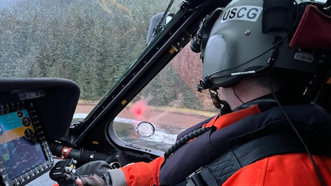 An Air Station Sitka pilot aboard an MH-60 Jayhawk helicopter locates an individual stranded on shore near Freshwater Bay, Alaska, Oct. 19, 2022. The individual and his two dogs swam to shore after his vessel capsized.