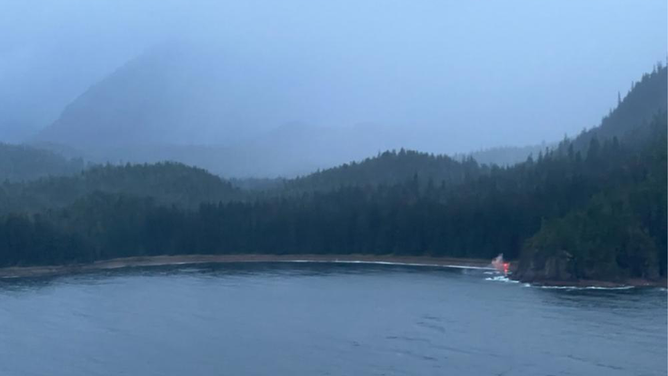 A mariner signals an Air Station Sitka aircrew with a flare after his vessel capsized in Freshwater Bay, Alaska, Oct. 19, 2022. The owner and his two dogs were reportedly in good condition during the time of the rescue.