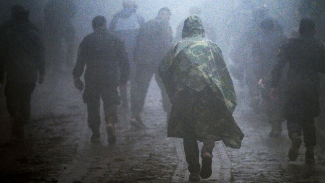 Members of the Salvadoran armed forces walk in the area where five soldiers were killed by a landslide following the passage of Tropical Storm Julia, in Comasagua, El Salvador, on October 10, 2022. - Julia was downgraded to a tropical depression after leaving six people dead in El Salvador and Honduras and flooding and property damage in Nicaragua, Guatemala and Panama.