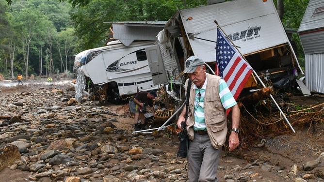 CANTON, USA - AUGUST 19: An elderly passes by damaged trailers as Governor Roy Cooper declared a State of Emergency in Haywood County after the heavy rainfall from depression Fred devastated the area putting businesses under six feet of water and mud and destroying a campground while several residents are dead or missing in Canton, NC, United States on August 19, 2021. (Photo by Peter Zay/Anadolu Agency via Getty Images)