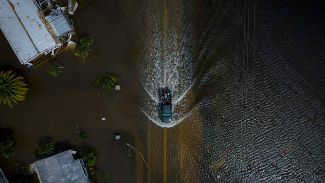 An aerial picture taken on September 29, 2022 shows a car driving through a flooded neighborhood in the aftermath of Hurricane Ian in Fort Myers, Florida.