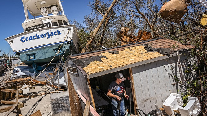 People clear debris in the aftermath of Hurricane Ian in Fort Myers Beach, Florida on September 30, 2022.