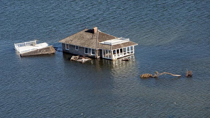 Aerial views of a house that was moved off its foundation and sits in the middle of the bay near Mantaloking, New Jersey after Superstorm Sandy hit.