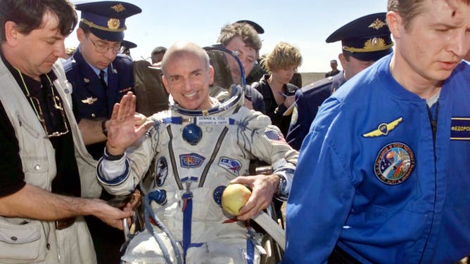 File photo: American space tourist Dennis Tito, 60, waves as he is helped into a wheelchair shortly after landing inside the Russian Soyuz space capsule May 6, 2001 near Arkalyk, Kazakhstan. Tito was returning from a six-day voyage to the International Space Station, a trip for which he paid $20 million.