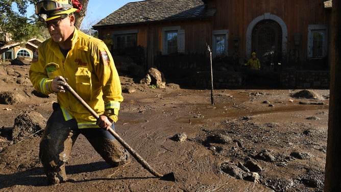Cal Firefighter Alex Jimenez walks out after marking a spot with a stick where he found a body under the mud at a house along Glen Oaks Drive in Montecito after a major storm hit the burn area Wednesday on January 10, 2018 in Montecito, California.